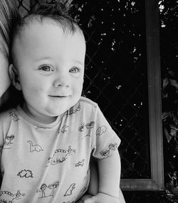 Close-up of cute baby boy by window