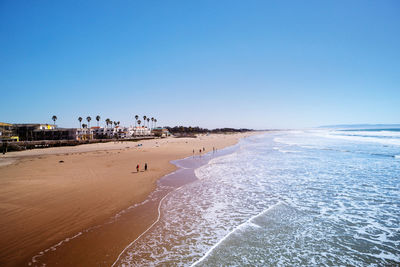 Scenic view of beach against clear blue sky