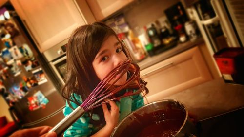 Portrait of girl licking chocolate in home