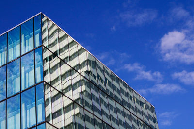 Low angle view of modern building against blue sky
