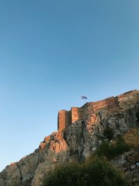 Low angle view of the acropolis against clear blue sky