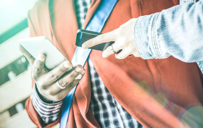 Close-up of couple using mobile phone