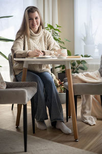 Young woman sitting on chair at home