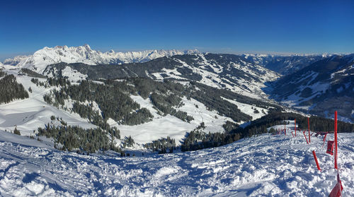 Scenic view of snowcapped mountains against blue sky