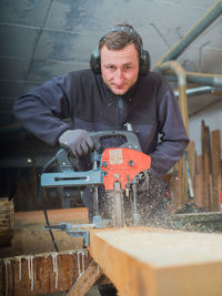 Portrait of man working on metal grate