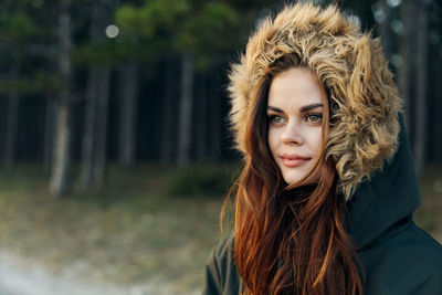 Young woman wearing fur hat while standing outdoors