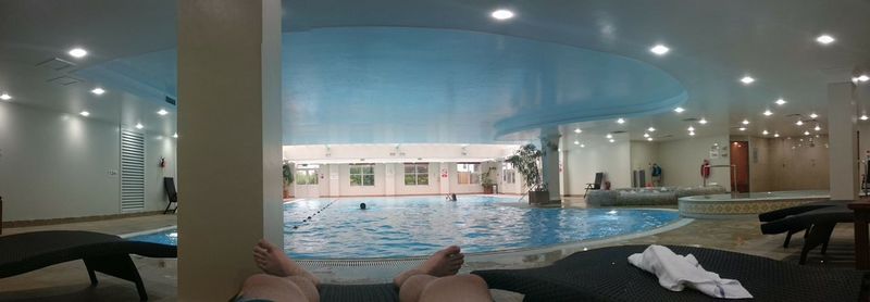 Low section of woman relaxing in swimming pool at home