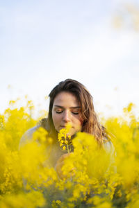 Portrait of woman smelling yellow flowers