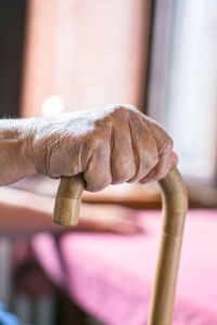 Elderly person's hand holding a walking stick