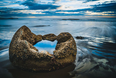 Rocks by sea against sky