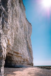 Rock formations on beach against sky