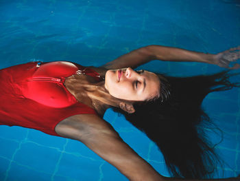 Midsection of woman swimming in pool