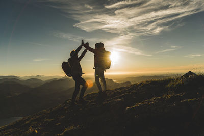 Austria, salzkammergut, cheering couple reaching mountain summit