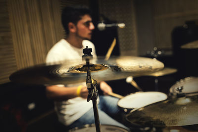 Close-up of man playing drum in darkroom