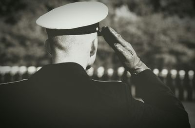 Rear view of military man saluting