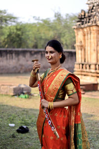 Portrait of smiling young woman wearing traditional clothing standing outdoors