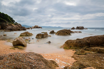 Rocks on beach against sky