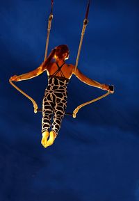 Woman with umbrella against blue sky