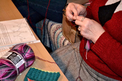 Midsection of woman knitting wool