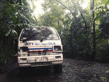 Abandoned car on railroad track in forest