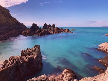 Scenic view of rocks in sea against sky