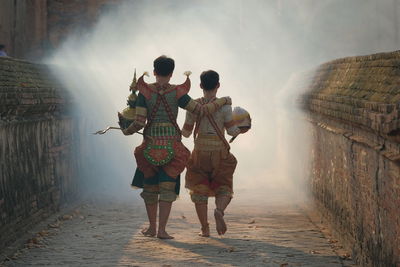 Rear view of couple walking in water