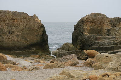 Rocks on beach against clear sky