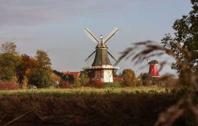 Traditional windmill on field against sky