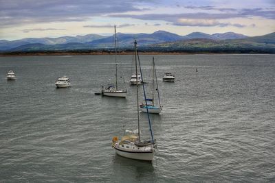 Sailboats in sea against sky