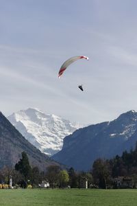 Person paragliding against mountain