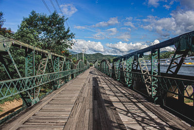 View of footbridge against cloudy sky
