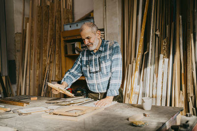 Senior carpenter examining picture frame at workshop