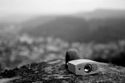 Close-up of padlock on rock against mountains