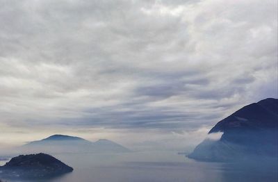 Scenic view of sea and mountains against sky