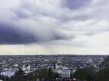 Cityscape against cloudy sky