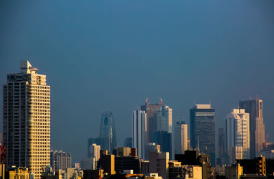 Modern buildings in city against clear sky