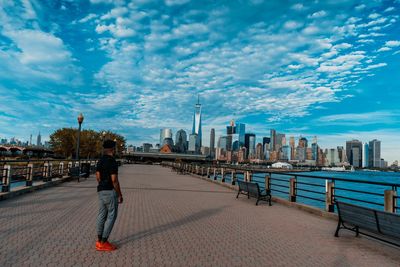 Man walking on footpath against buildings