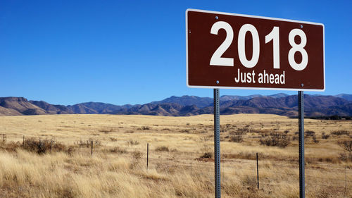 Information sign on roadside against clear blue sky