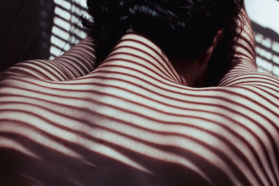 Rear view of shirtless man with shadow on back