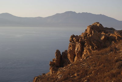 Rock formations by mountain against sky