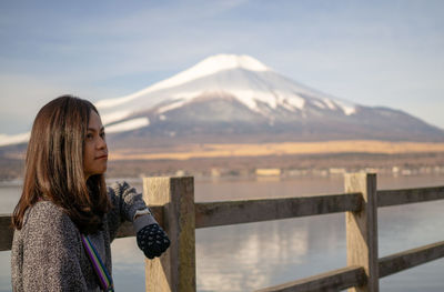 Portrait of woman against snowcapped mountains against sky