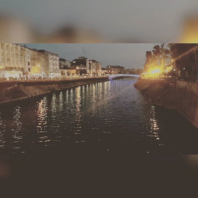 water, architecture, built structure, building exterior, reflection, waterfront, sunset, illuminated, river, city, sky, bridge - man made structure, rippled, canal, sun, building, night, outdoors, lens flare, no people