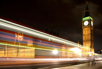 Light trails on street amidst buildings at night