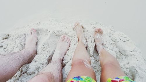 Low section of people relaxing on beach