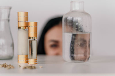 Close-up women looks through bottles on table