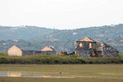 Houses on field against clear sky