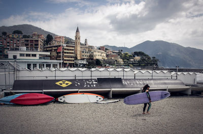 Rear view of people on boat in city against sky