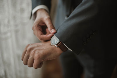 Midsection of businessman adjusting sleeve