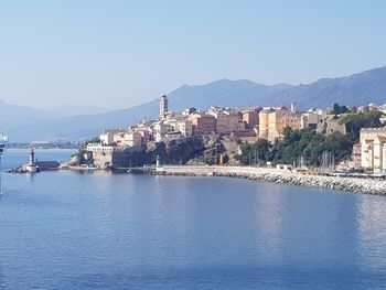 View of townscape by sea against clear sky