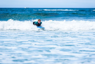 Man surfing in sea against sky